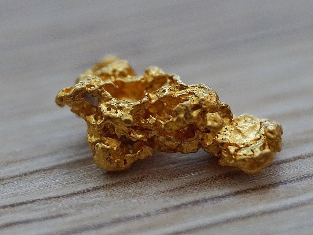 raw gold nugget on gray rough surface
