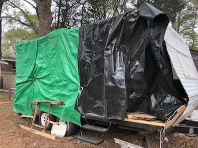 green and black plastic tarps covering side of trailer